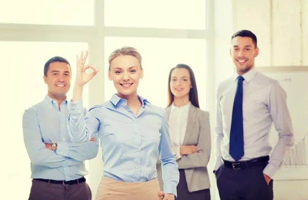 Lächelnde Geschäftsfrau zeigt Ok-Zeichen im Amt — Stockfoto