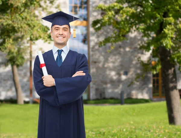 Smiling adult student in mortarboard with diploma — Stock Photo, Image