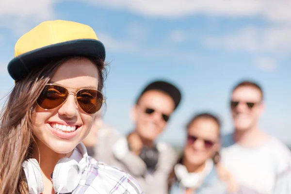 Teenage girl with headphones and friends outside — Stock Photo, Image