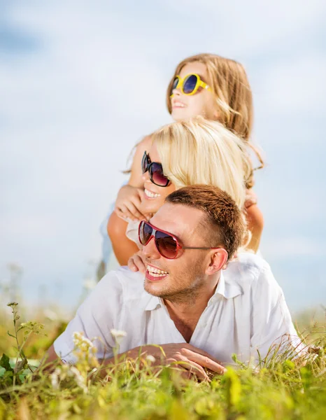 Famille heureuse avec ciel bleu et herbe verte — Photo