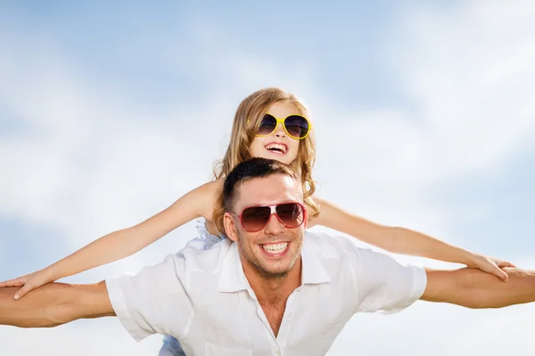 Feliz padre e hijo en gafas de sol sobre el cielo azul — Foto de Stock