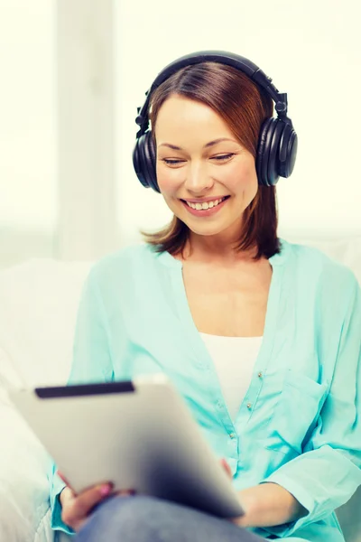 Femme souriante avec tablette PC et écouteurs — Photo