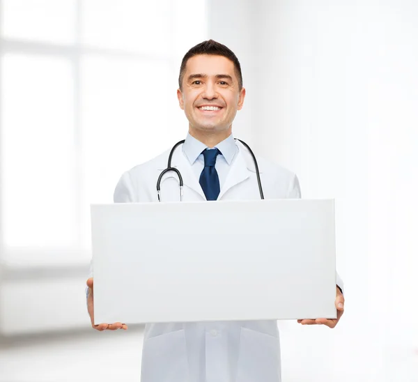 Улыбающийся доктор держит белую доску — стоковое фото