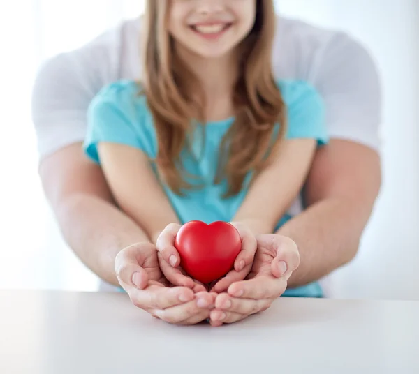 Close up of man and girl holding red heart shape — Stock Photo, Image