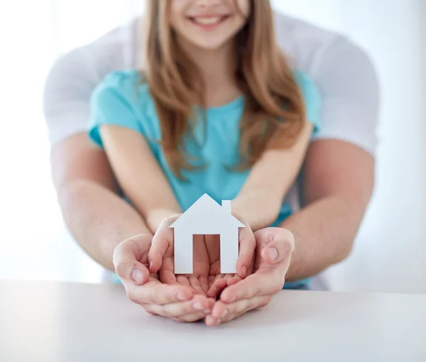 Крупним планом чоловік і дівчина руки з паперовим будинком — стокове фото