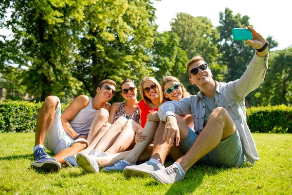 Smiling friends with smartphone making selfie — Stock Photo, Image