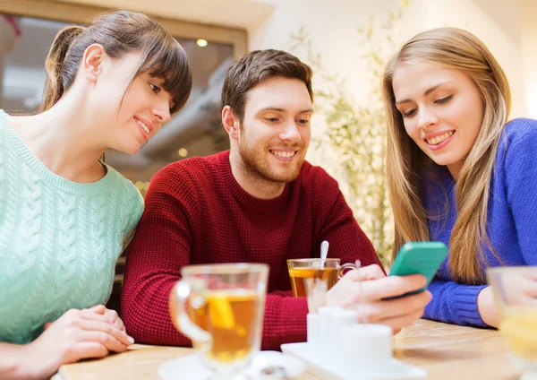 Grupo de amigos con reunión de teléfonos inteligentes en la cafetería —  Fotos de Stock