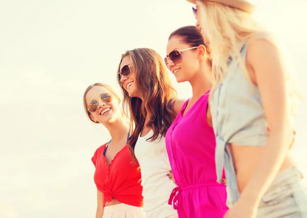 Grupo de mujeres sonrientes en gafas de sol en la playa — Foto de Stock