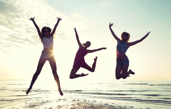 Счастливые подруги танцуют и прыгают на пляже — стоковое фото