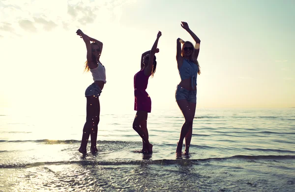 Happy kvinnliga vänner dansa på stranden — Stockfoto