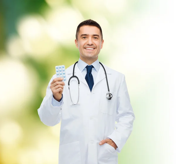Uśmiechnięty mężczyzna lekarz w białym płaszczu z tabletek — Zdjęcie stockowe