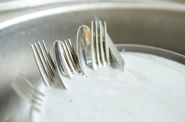 Close up of dirty dishes washing in kitchen sink — Stock Photo, Image