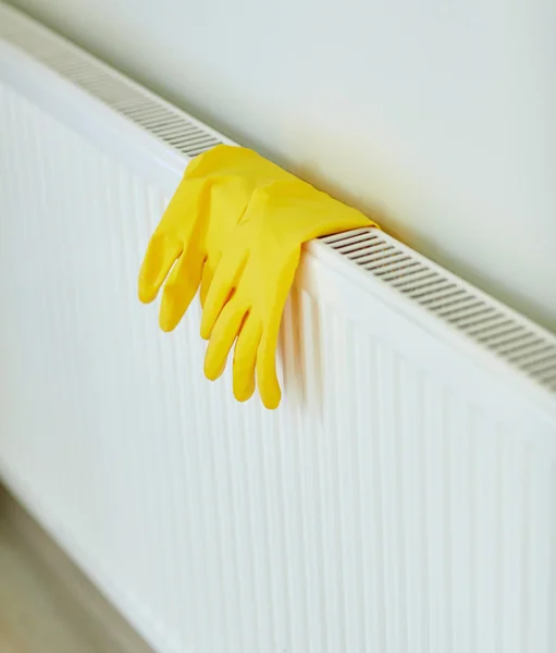 Gros plan de gants en caoutchouc suspendus au radiateur — Photo