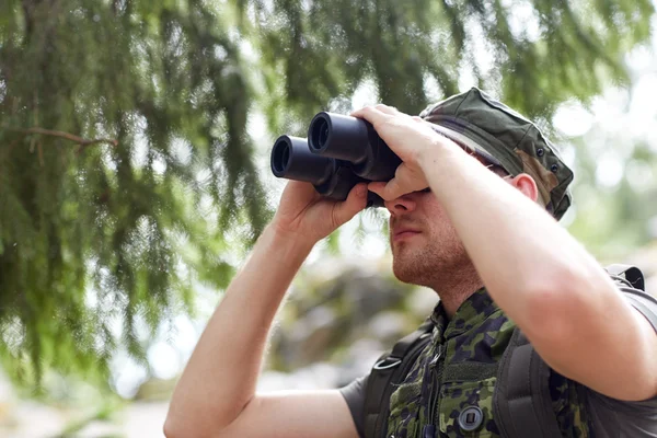 Jeune soldat ou chasseur avec jumelles en forêt — Photo