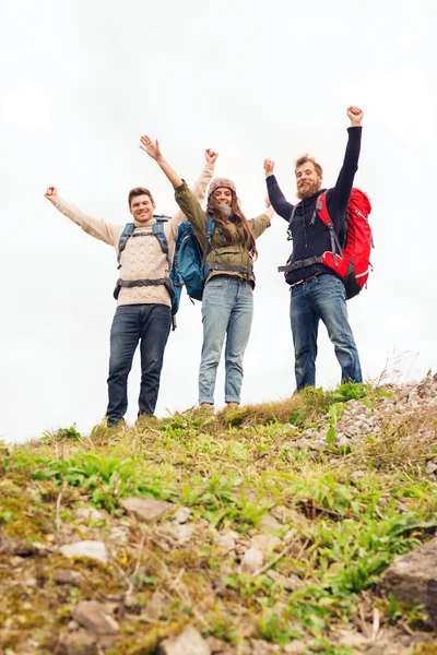 Grupo de amigos sonrientes con mochilas senderismo — Foto de Stock