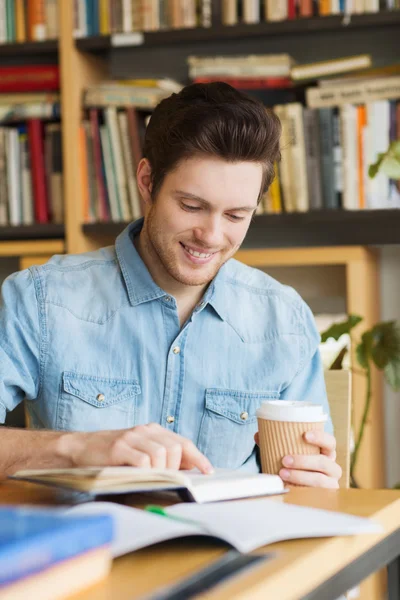 Happy student čtení knihy a pití kávy — Stock fotografie
