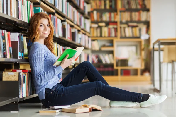 Student szczęśliwy dziewczyna czytania książki w bibliotece — Zdjęcie stockowe