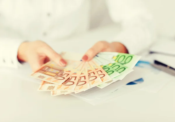 Mãos de mulher com dinheiro em euros — Fotografia de Stock