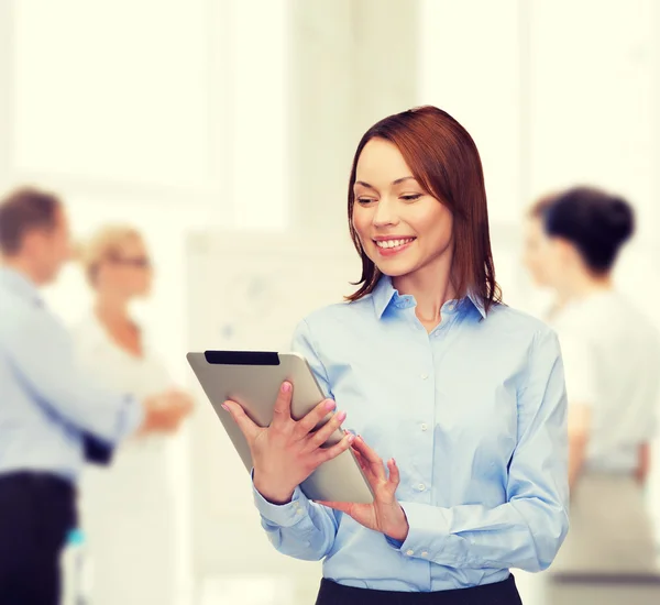 Lachende vrouw kijken naar tablet pc op kantoor — Stockfoto