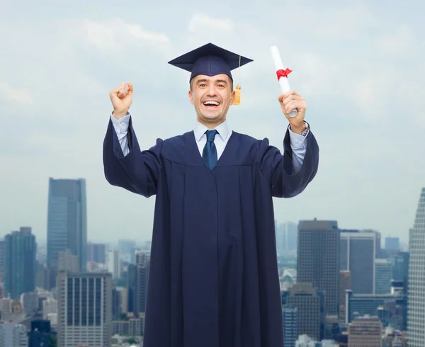Lachende volwassen student in mortarboard met diploma — Stockfoto