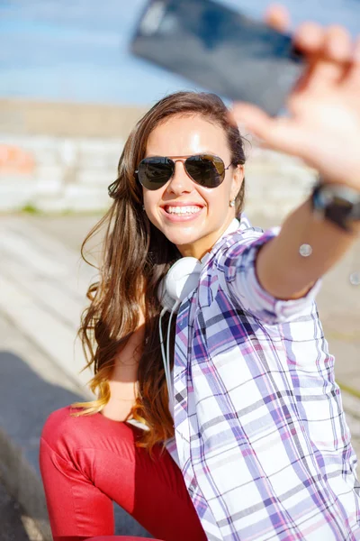 Adolescente sonriente tomando fotos con teléfono inteligente — Foto de Stock