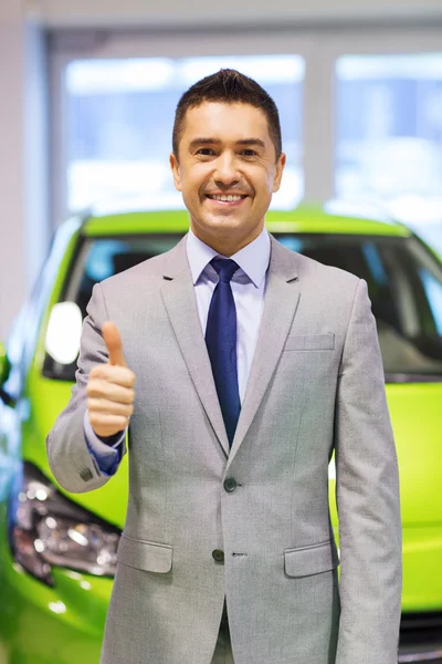 Hombre mostrando pulgares hacia arriba en el auto show o salón de coches —  Fotos de Stock