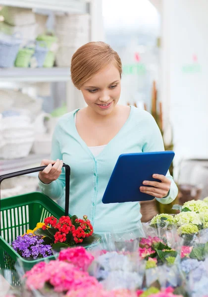 Frau mit Tablet-PC und Korb im Blumenladen — Stockfoto