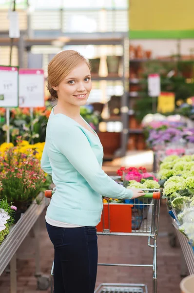 Donna felice con carrello della spesa comprare fiori — Foto Stock