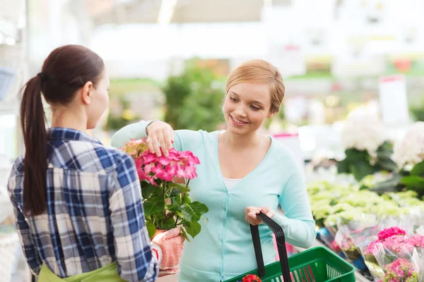 Happy women choosing flowers in greenhouse — Stock Photo, Image