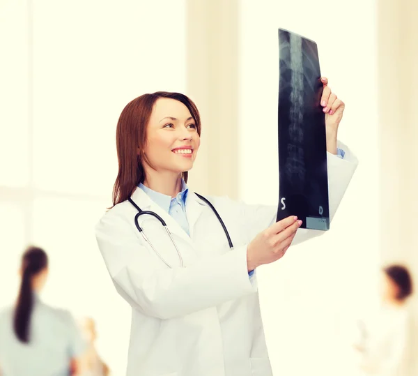 Sorridente medico femminile guardando i raggi X — Foto Stock