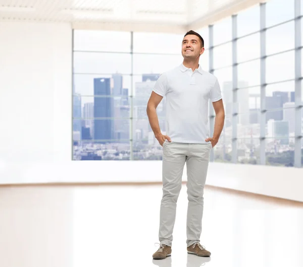 Uomo sorridente con le mani in tasca alzando lo sguardo — Foto Stock