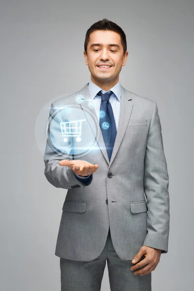 Businessman showing shopping trolley hologram — Stock Photo, Image