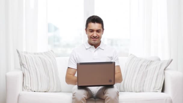 Happy man working with laptop computer at home — Stock Video