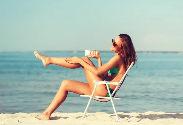 Sonriente joven tomando el sol en el salón en la playa — Foto de Stock