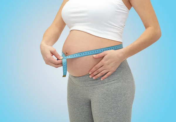 Nahaufnahme einer schwangeren Frau, die ihren Bauch misst — Stockfoto