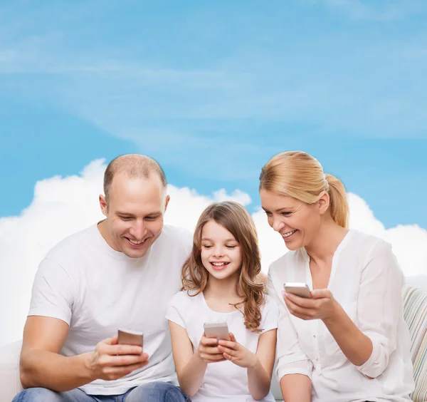 Happy family with smartphones — Stock Photo, Image