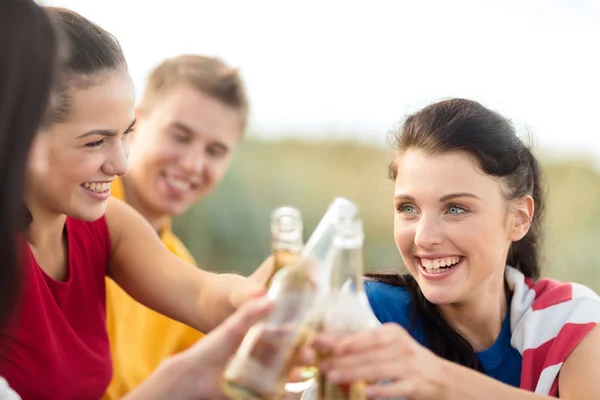 Gelukkige vrienden met bierflessen op strand — Stockfoto