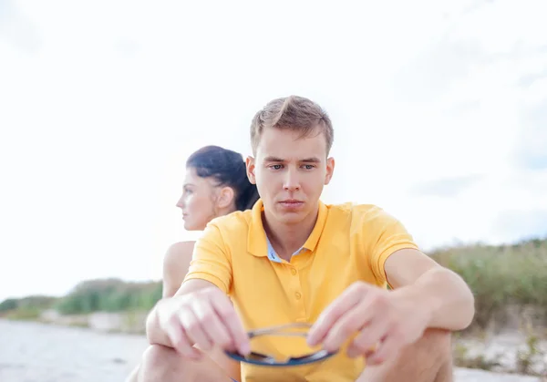 Unhappy couple sitting on beach — Stock Photo, Image