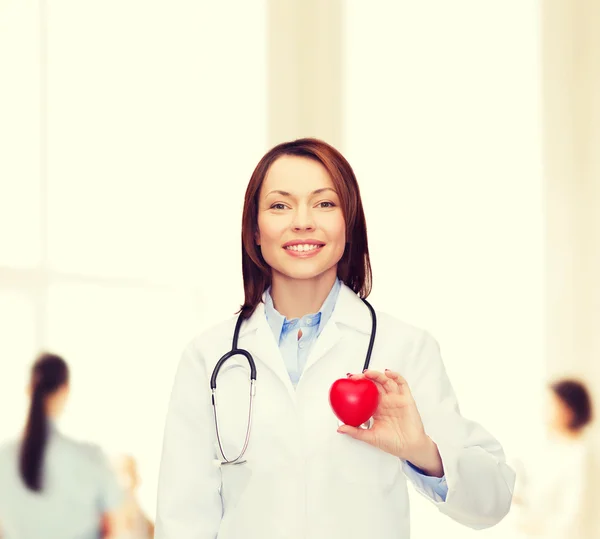 Glimlachende vrouwelijke arts met hart en stethoscoop — Stockfoto