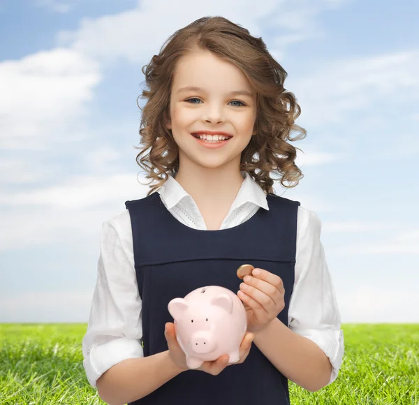 Menina feliz segurando porquinho banco e moeda — Fotografia de Stock