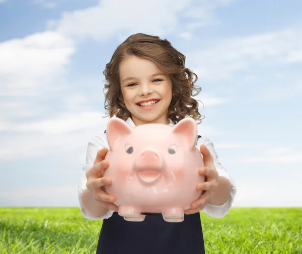 Gelukkig meisje bedrijf piggy bank — Stockfoto