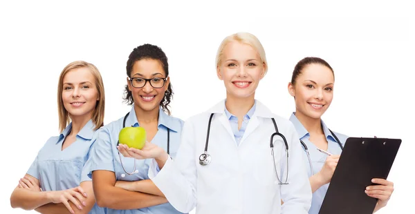 Usmívající se žena lékaře a zdravotní sestry s zelené jablko — Stock fotografie