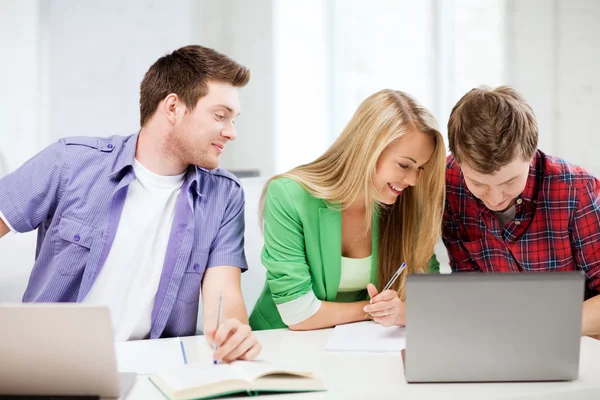 Estudiantes escribiendo algo en la escuela — Foto de Stock