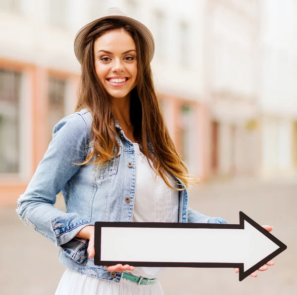 Chica mostrando la dirección con flecha en la ciudad — Foto de Stock