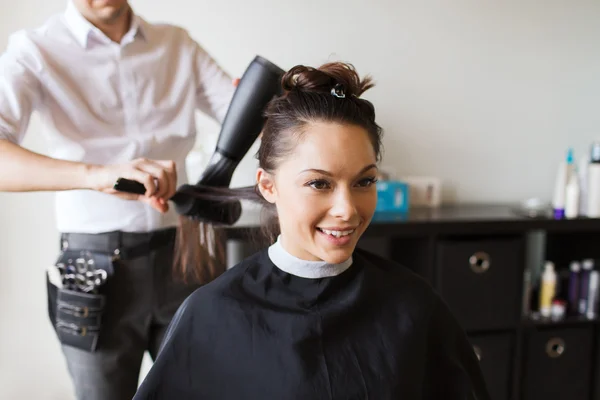 Mujer feliz con estilista haciendo peinado en el salón —  Fotos de Stock