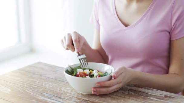 Primer plano de la mujer joven comiendo ensalada en casa — Vídeos de Stock