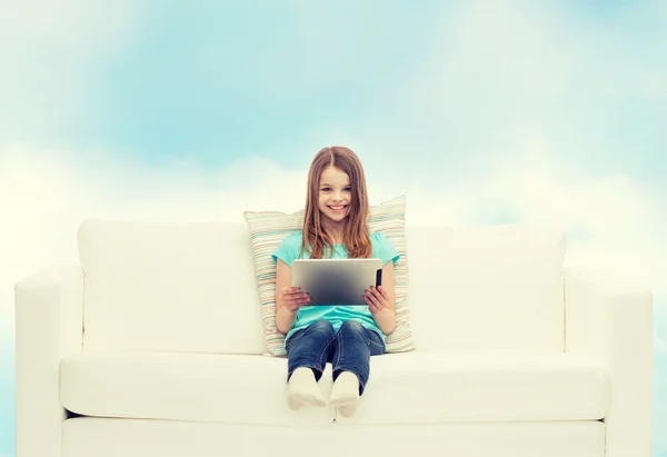 Niña sentada en el sofá con la tableta PC — Foto de Stock