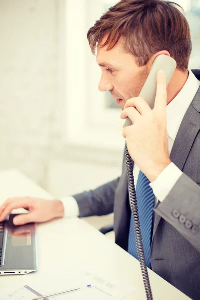 Empresario con ordenador portátil y teléfono — Foto de Stock