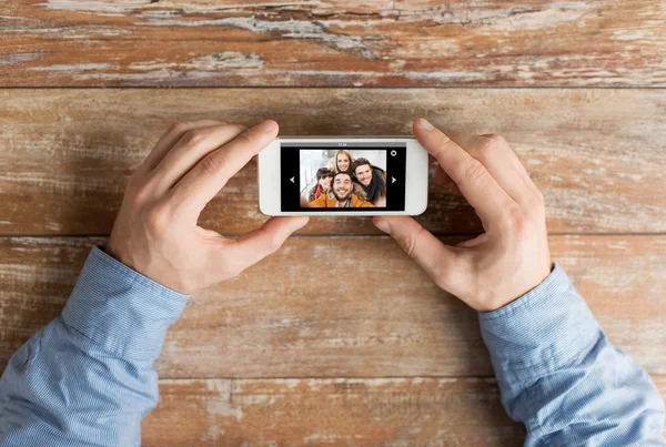 Närbild av manliga händer med foto på smartphone — Stockfoto