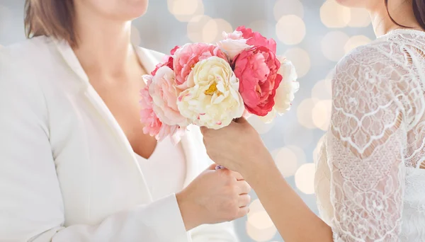 Close up of happy lesbian couple with flowers — Stock Photo, Image